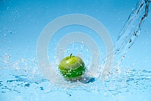 Green apple in clear water splash