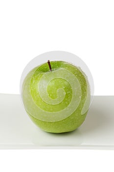 Green Apple Closeup on White Plate