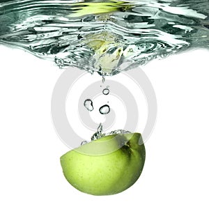 Green apple dropped into water photo