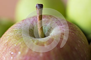 A red apple in drops of water. Macro shooting. Selective focus.