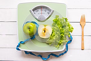 Green apple, fresh vegetable with weight scale and measuring tape for the healthy diet slimming