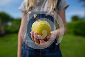 A green apple in a hand reaching out