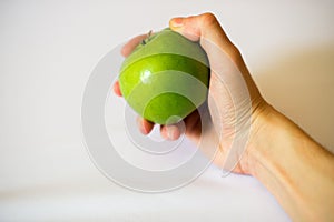 Green apple in hand on a white background