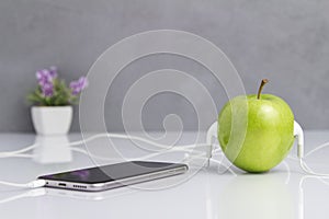 Green Apple with Headset Connected to Phone