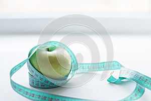 Green apple with measuring tape isolated on white background.Diet concept.place for text.