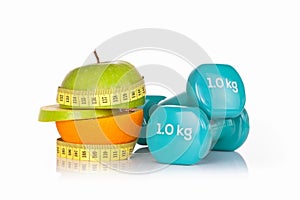 Green apple with measuring tape with a pair of blue fitness dumbbells.