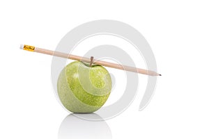 Green apple and pencil. Studio shot isolated on white