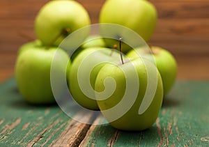 Green apple placed in the fron before other fruit
