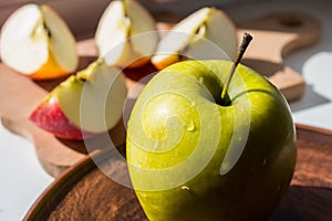 Green apple on a plate in the sun