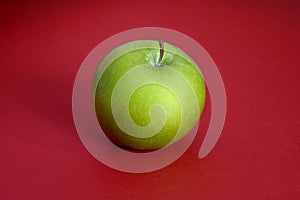 Green apple on red background