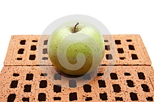 Green apple on red brick stone