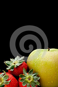 A green apple and red strawberries