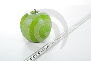 Green apple with a ruler