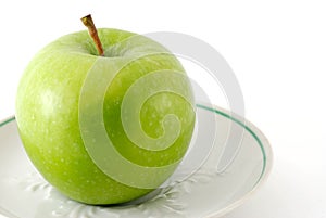 Green apple on a saucer