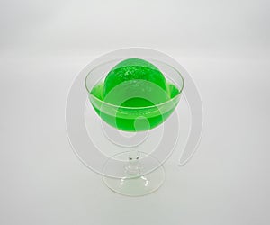 Green Apple Soda ice ball in clear cocktail glass isolated on white