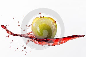 Green apple and splash of red juice on white background