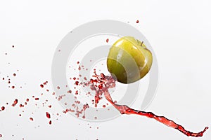 Green apple and splash of red juice on white background.