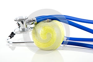 Green apple and stethoscope on white background