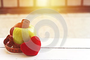 green apple with tape measure and red heart cotton on white wood table,Concept for diet, healthcare, nutrition or medical insuranc