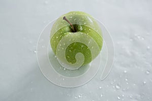 Green apple with water droplets