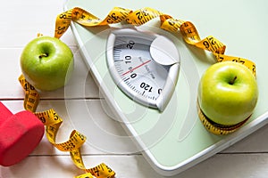 Green apple with weight scale and measuring tape for the healthy diet slimming