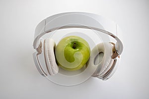 Green apple in which headphones are connected. The music player in the shape of an apple with headphones.Fantasy on the theme of
