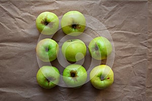 Green apples on beige paper background