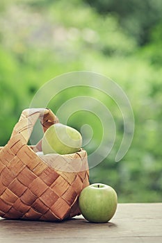 Green apples in a birchbark basket photo