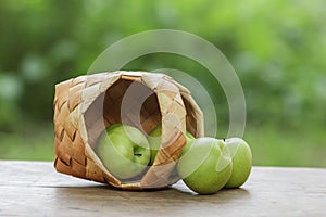 Green apples in a birchbark basket photo