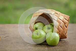 Green apples in a birchbark basket
