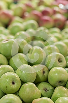 Green apples in a box in the store. green apples in boxes on market shelves. grocery shopping concept. healthy food. vertical phot