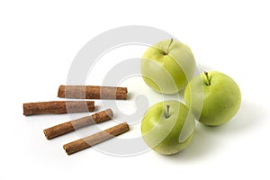 Green apples and cinnamons isolated on white background