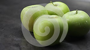 Green apples lie on the table in the kitchen