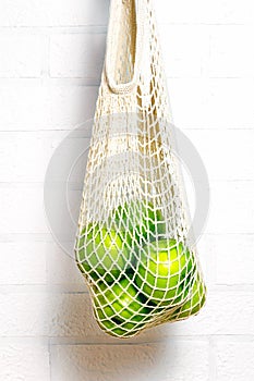 Green apples in mesh bag. Copy space.