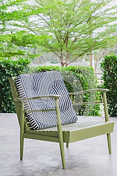 Green armchair in a cafe on cement floor.