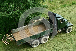 Green army truck from 1950s modified for timber transport photo