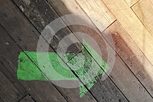 Green arrow on wooden floor, Empty with copy space for text.