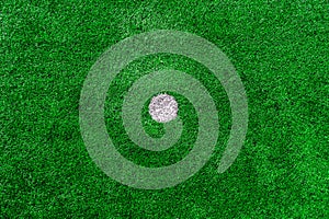 Green artificial grass texture on the football field, white circle in the middle .