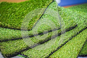 Green artificial turf rolled. Probes of artificial turf, floor coverings for playgrounds.