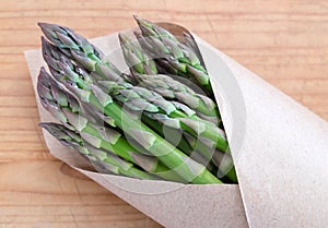 Green asparagus from a farmers market in brown paper packaging -