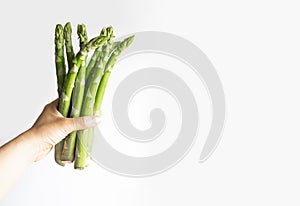 Green asparagus in the hands of a girl. Bunch of ripe fresh asparagus. Healthy organic food. Cooking in home. Natural vitamins