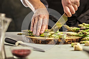 Green asparagus kept in men`s Chef cook hands