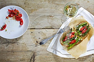 Green asparagus, tomatoes and parmesan gratinated on bread and a