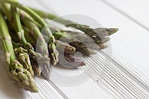 Green asparagus on white wooden background