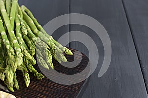 Green asparagus, on a wooden board on a table. Summer vegetables. Healthy food. A vegetarian. Free space for text. Copy sapce