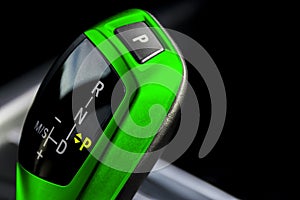 Green Automatic gear stick of a modern car. Modern car interior details. Close up view. Car detailing. Automatic transmission leve