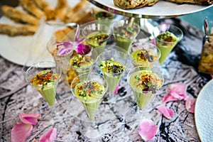 Green avocado cocktail shots served on catering buffet table