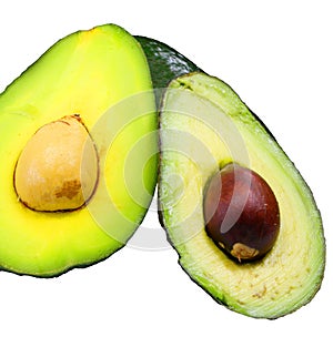 green avocado with a large seed in the middle on white background