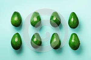 Green avocado pattern on blue background. Top view. Pop art design, creative summer food concept. Organic avocadoes in