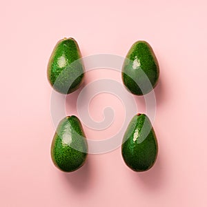 Green avocado pattern on pink background. Top view. Pop art design, creative summer food concept. Organic avocadoes in